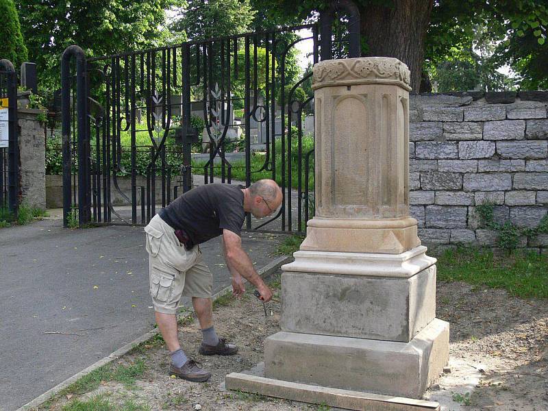 Akademický sochař Marek Ludmila měří podstavec pod křížem u hlavní brány Městského hřbitova v Hranicích. Pracuje teď na výrobě jeho posledních dvou částí.