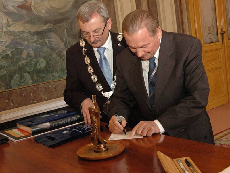 Exprezident podepisuje drobný dárek pro hradišťského místostarostu Evžena Uhra.