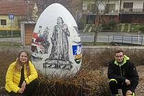 Nápad Davida Palkoviče, namalovat na obří vánoční vejce v rámci velikonoční výzdoby Komenského a pamětihodnosti Komně realizovala Petra Mojžíšková. Oba na snímku