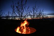 Oheň v sudu mezi kvetoucími meruňkami v  sadech společnosti Lukrom plus, 9. března 2023, Buchlovice, Uherskohradišťsko.