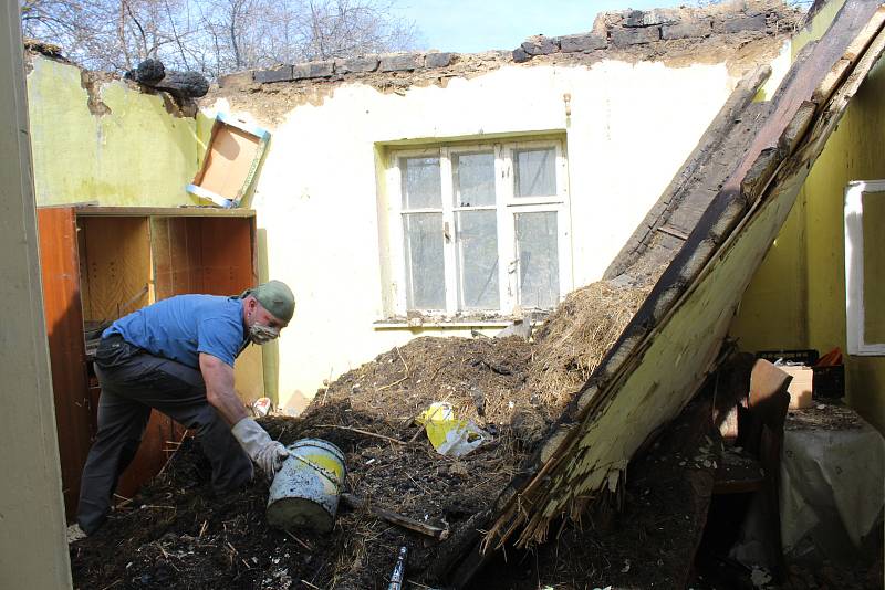 Úklid po požáru domku ve Vápenicích.