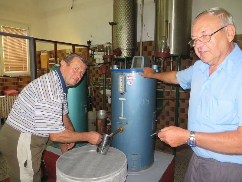 Páleničáři Jan Žufánek a Jan Štokman kontrolují kvalitu čerstvě vypálené kořalky.