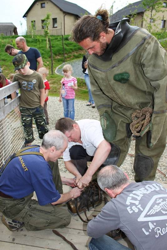 Čtyři potápěči měli plné ruce práce, aby jednoho před ponorem do vody oblékli a pak vysvlékli.