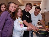 U PLOTNY. David Vaculík (vpravo) s žáky hradišťské sportovní školy při přípravě jídla.   