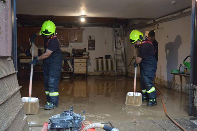 Členové SDH Kudlovice při úklidu suterénu v jednom z Kudlovických domů v pondělí 26. srpna.