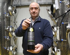 Břetislav Jakubík drží v ruce vzorek Rulandského šedého ročníku 2021, jenž získal Zlatou medaili Salonu vín pro rok 2024