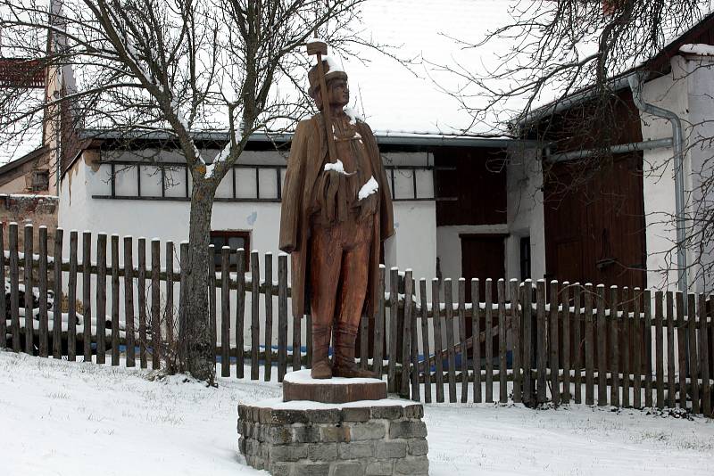 Dřevěná socha fašankového gazdy – fašančára v životní velikosti, která se podobá místní dvojici folkloristů Stanislavu Popelkovi a Františku Jankových.