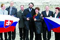 Dvanáct představitelů obcí z obou stran hranice se nakonec společně vyfotografovalo na slovenské mohyle na Bradle.