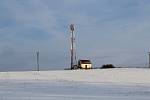 Hostějov se sněhovou pokrývkou. Radiotelekomunikační věž a vodojem.