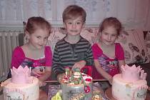 Trojčata ze Strání u dortu při oslavě čtvrtých narozenin. Zleva Mariánka, Martínek, Rozárka.