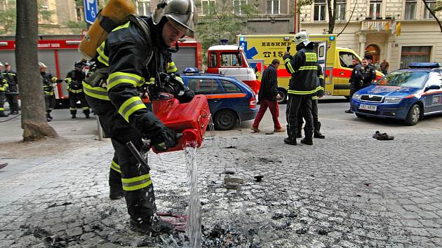 TRAGICKÁ NEHODA. Výsledkem pořáru karlínské trafostanice je těžce popálený pracovník Pražské energetiky. Hasič na snímku polévá vodou zbytky ohořelého oblečení zraněného muže. 