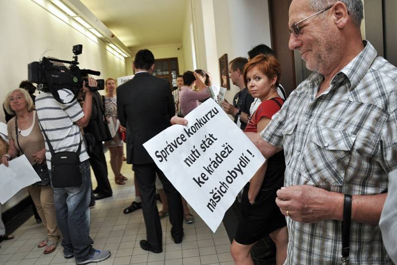 Desítky občanů s hesly v rukou přišly sledovat jednání přímo k soudu; před dveřmi jednací síně je ale na pokyn justiční stráže lidé museli odložit.