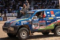 V cíli slavné rallye Dakar. Jiří Janeček se vyklání z vozu, za volantem je Viktor Chytka.