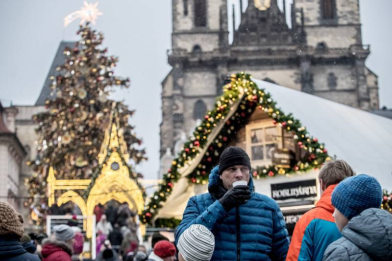 Lidé pijí horké nápoje na vánočním trhu na Staroměstském náměstí v Praze 11. prosince.