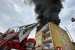 Střechu panelového domu V Praze 4 zachvátil požár.