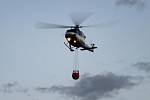 Požár porostu v Libni hašený z vrtulníku pomocí bambi vaku.