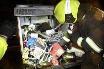 Muž uvízl v kontejneru na elektroodpad v Holešovicích. Vyprostit ho museli hasiči ve spolupráci se strážníky městské policie.