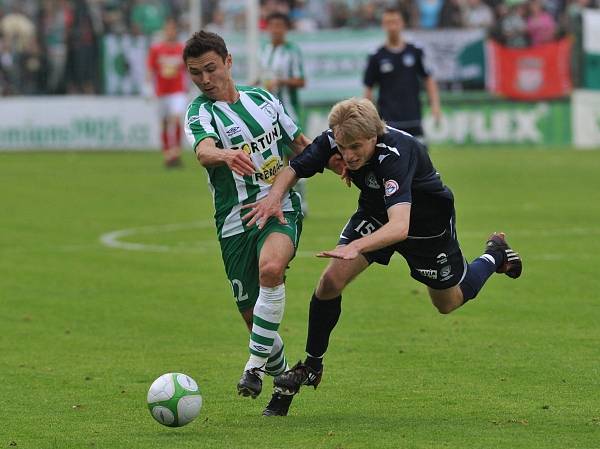 Jiří Perůtka ztrácí stabilitu v běžeckém souboji s domácím útočníkem Azizem Ibragimovem.