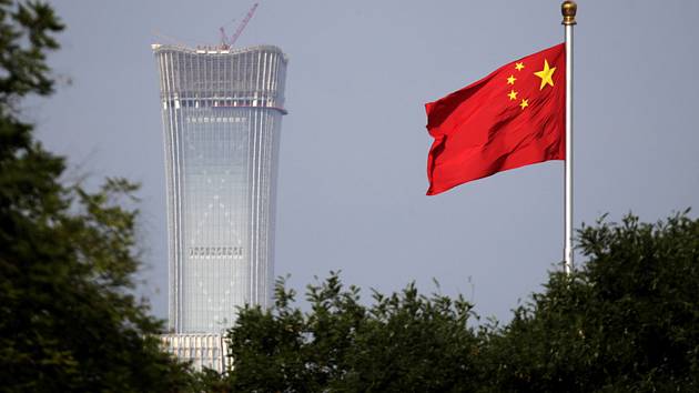Čínská vlajka v Pekingu, v pozadí mrakodrap China Zun. Ilustrační foto.