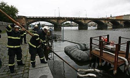 Pražští hasiči odstraňují skvrnu z Vltavy, kterou zapříčinil únik chemikálií.