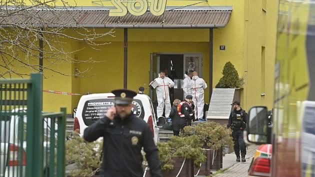 Policisté před budovou Středního odborného učiliště Ohradní v Praze 4, kde útočník s mačetou 31. března 2022 smrtelně zranil učitele.