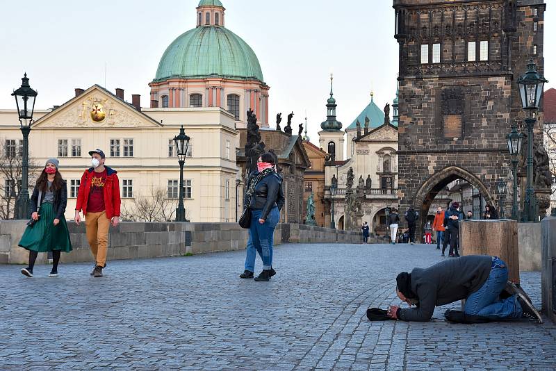 Prázdné ulice Prahy a lidé s rouškami 18. března 2020. Karlův most.