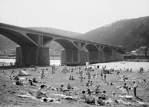 Pražané chytají v létě 1962 sluneční paprsky u Branického železničního mostu (lidově přezdívaného most Inteligence). Sedící pár v popředí fotky jsou rodiče editora Pražského deníku. Poznáte i vy někoho na fotce?