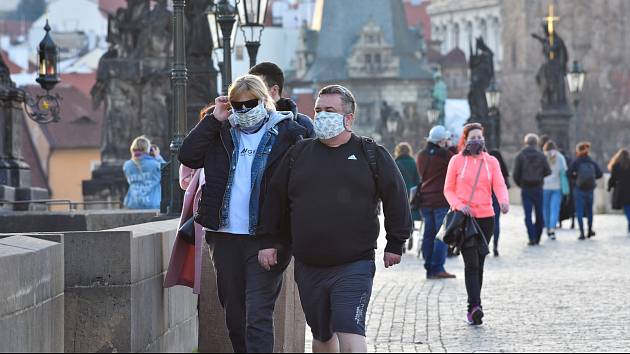 Prázdné ulice Prahy a lidé s rouškami 18. března 2020. Karlův most.