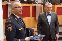 Ředitel pražských hasičů převzal z rukou primátora pamětní list a medaili.