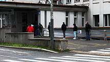 Lidé čekají v Nemocnici Na Bulovce ve frontě na odběr vzorků kvůli novému koronaviru.