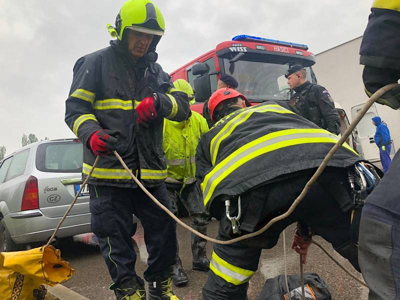 Pražští hasiči a potápěči pátrají po dělníkovi, který spadl do kanálu v Patočkově ulici.