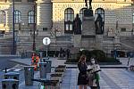 Prázdné ulice Prahy a lidé s rouškami 18. března 2020. Slečny se snaží aktivovat koloběžku, Václavské náměstí.