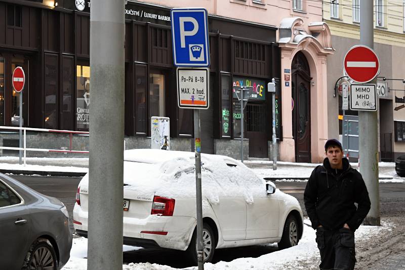 Zasněžené auto v místě s parkovací dobou omezenou dopravní značkou