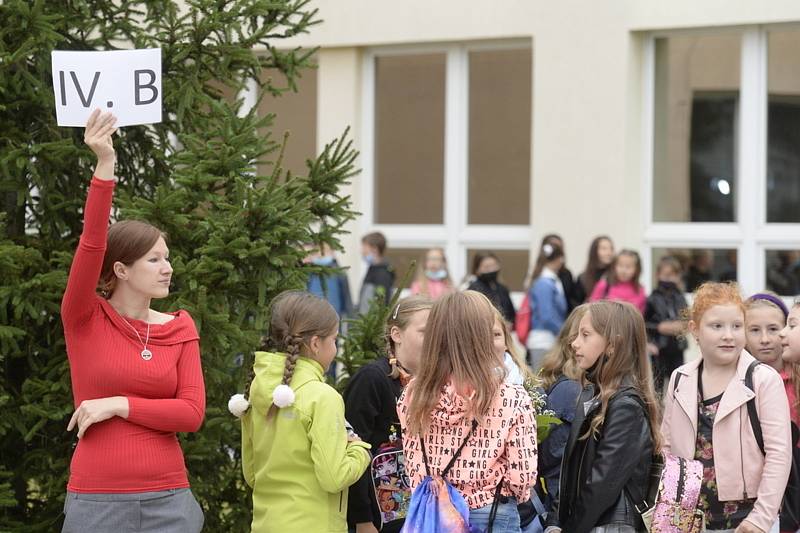 Žáci se svou třídní učitelkou čekají 1. září 2020 před Masarykovou základní školou v Újezdu nad Lesy v Praze 9 na zahájení nového školního roku.