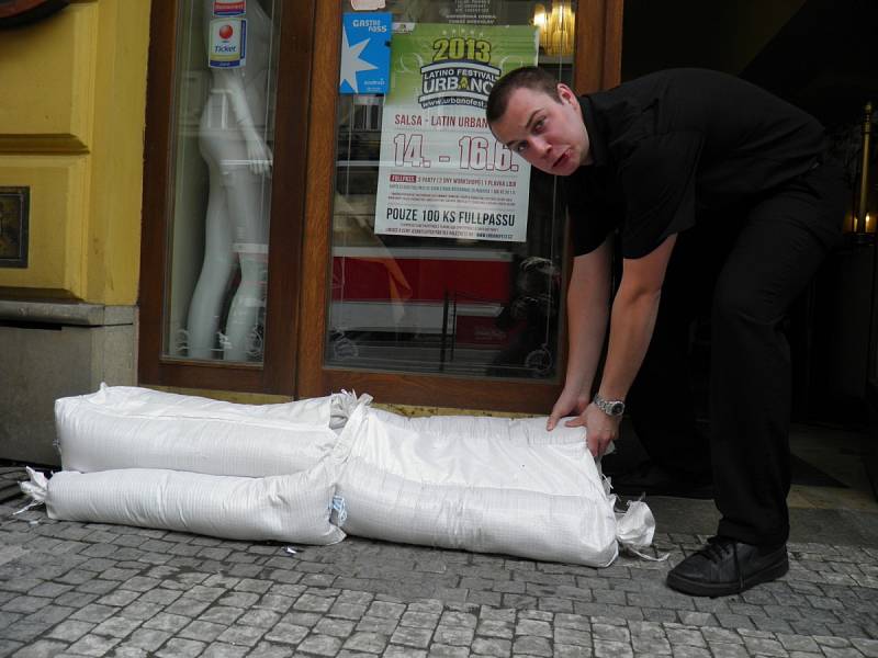 ČÍŠNÍK David Čada z karlínské restaurace přichystal pytle s pískem na práh restaurace. „Předevčírem jsme se báli, teď ale věříme, že se nám voda snad vyhne.“ 