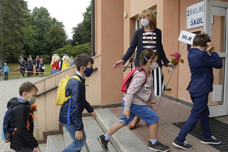 Žáci s nasazenými rouškami vchází 1. září 2020 do Masarykovy základní školy v Újezdu nad Lesy v Praze 9.