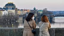 Prázdné ulice Prahy a lidé s rouškami 18. března 2020. Osamělé turistky na Karlově mostě.