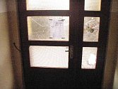 Poničená skleněná výplň dveří v ulici 5. května.