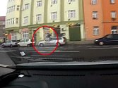 Muž skákající po autě. 