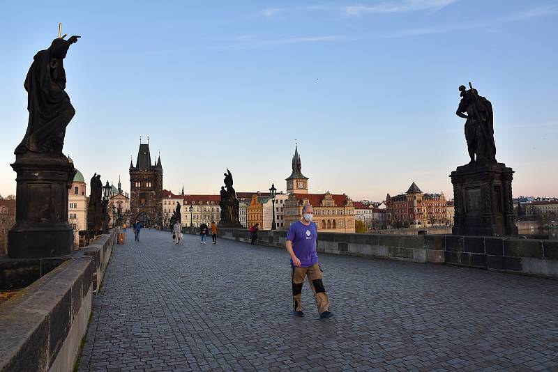 Prázdné ulice Prahy a lidé s rouškami 18. března 2020. Karlův most v době karantény.