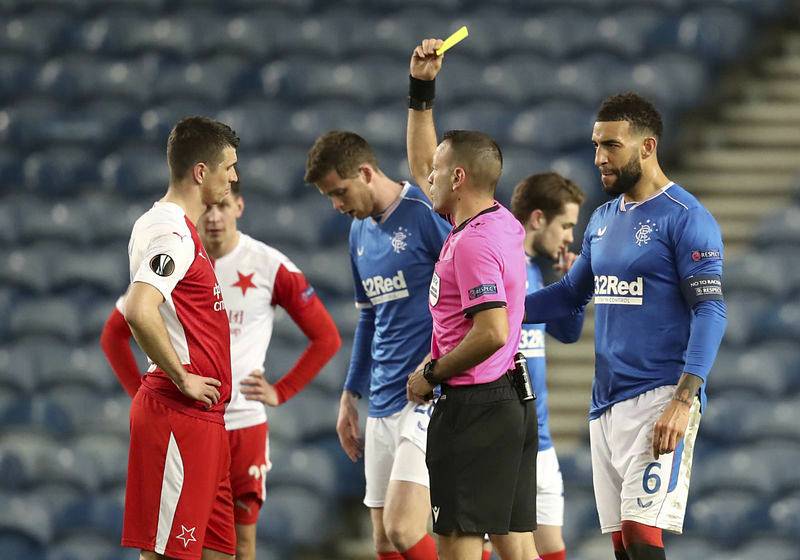 Odveta osmifinále fotbalové Evropské ligy: Glasgow Rangers - Slavia Praha, Ondřej Kúdela (vlevo) ze Slavie dostává žlutou kartu.