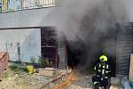 V Krči hořel stavební stroj v garážích.