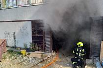 V Krči hořel stavební stroj v garážích.