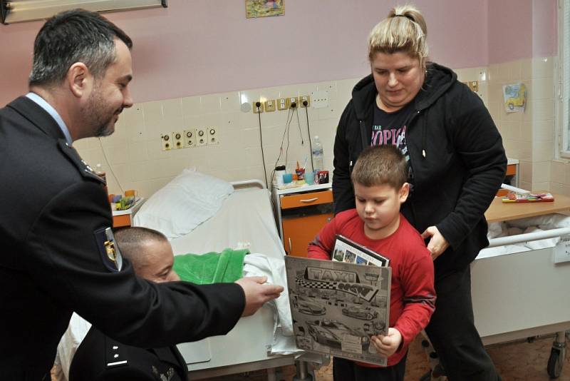 S předčasnou vánoční nadílkou navštívili lůžkové oddělení pediatrie Thomayerovy nemocnice v pražské Krči policejní těžkooděnci - příslušníci speciální pořádkové jednotky pražské policie. Sbírku na dárky pro nemocné děti pořádají mezi sebou již deset let.