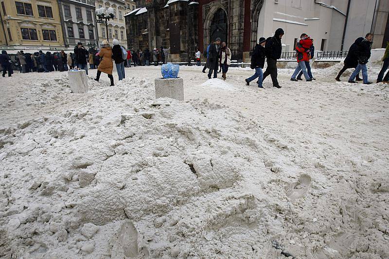 Turisté procházejí kolem hromady neodklizeného a špinavého sněhu na Staroměstském náměstí v Praze.