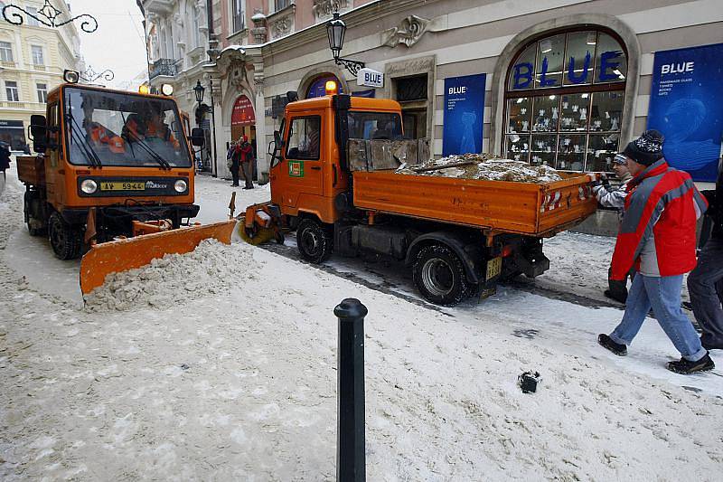 Pracovníci Pražských služeb odklízejí čerstvě napadaný sníh v Celetné ulici v Praze.