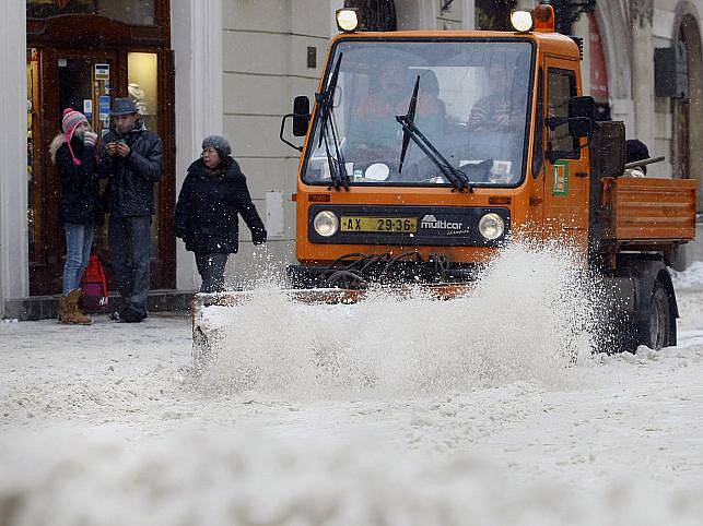 Pracovníci Pražských služeb odklízejí čerstvě napadaný sníh v Celetné ulici v Praze.