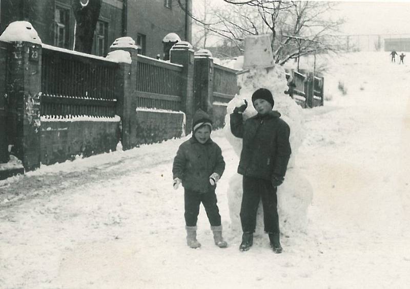 Vykáňská. Helena Černá (vlevo) s Pepíkem Šindelářem v roce 1970. V klidné části Nových Strašnic se mohly děti dosyta vyblbnout, nehrozilo jim žádné nebezpečí ani uprostřed silnice. Vzadu na fotce lyžují děti z  kopce pod sportovním hřištěm.