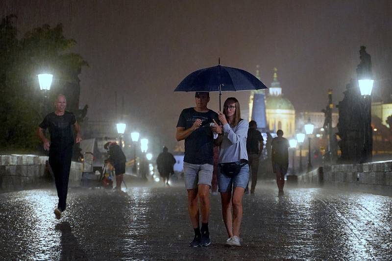 Karlův most - někteří turisté a fotografové si užívají noční déšť, 19. 8. 2022.