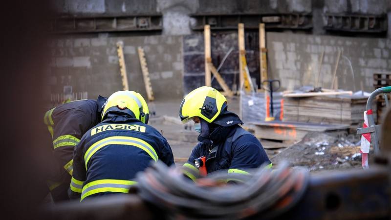 Pražští hasiči se snaží vyprostit dělníka, jehož na Smcíhově zavalila zemina. Zásah probíhá v těžkých podmínkách.